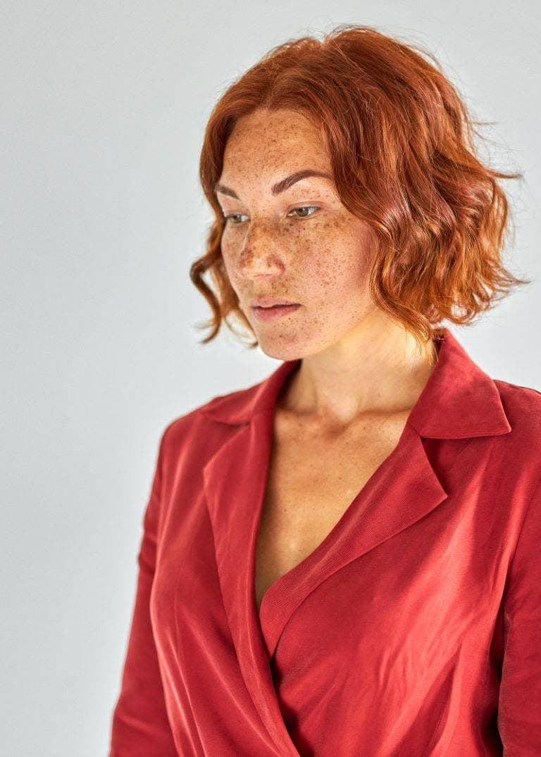 pensive redhead lady in dress isolated